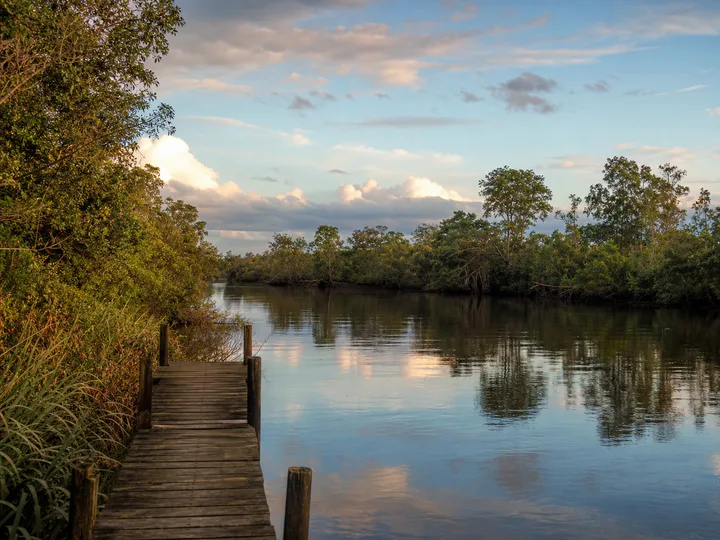Calm tropical wetland river and wooden jetty in the Beaufort district of Sabah