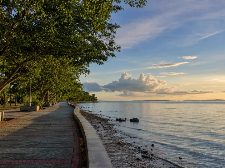 Tree-lined public waterfront promenade and calm coast representing Sipitang Sabah